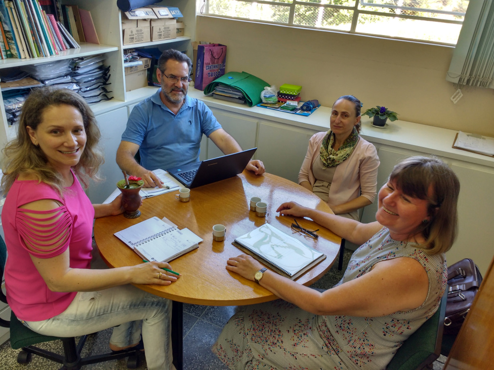 Foto com quatro membros da Comissão de Articulação do projeto sentados em volta de uma mesa