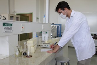 Pessoa realizando testes com alimentos em laboratório
