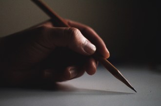 imagem de uma mão segurando uma caneta