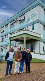 Quatro homens, lado a lado, em pé, em frente ao prédio da UFFS Unidade Seminário