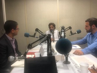 imagem de dois professores sendo entrevistados numa mesa de rádio